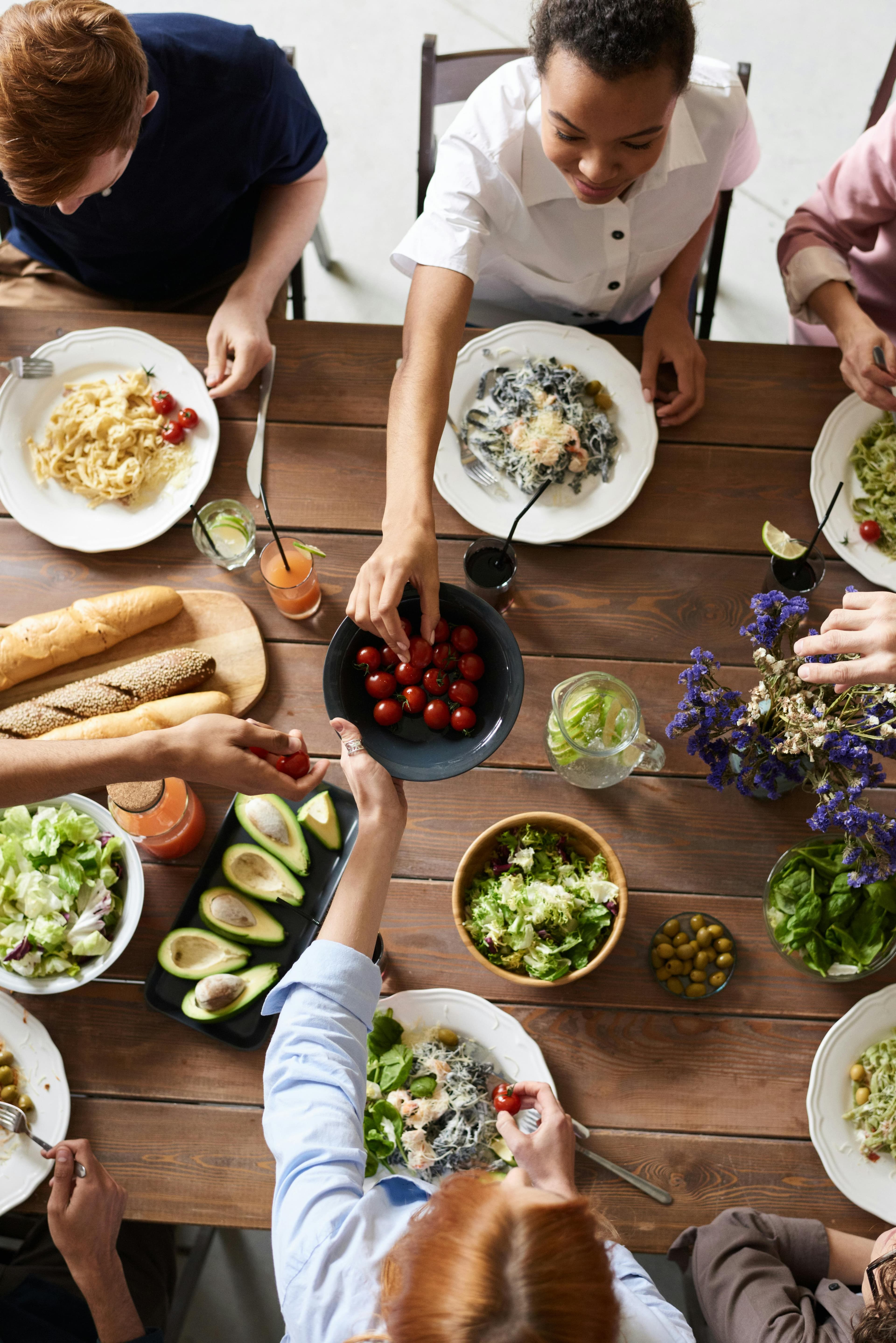 Image of people sitting around the dinner table enjoying a meal together.